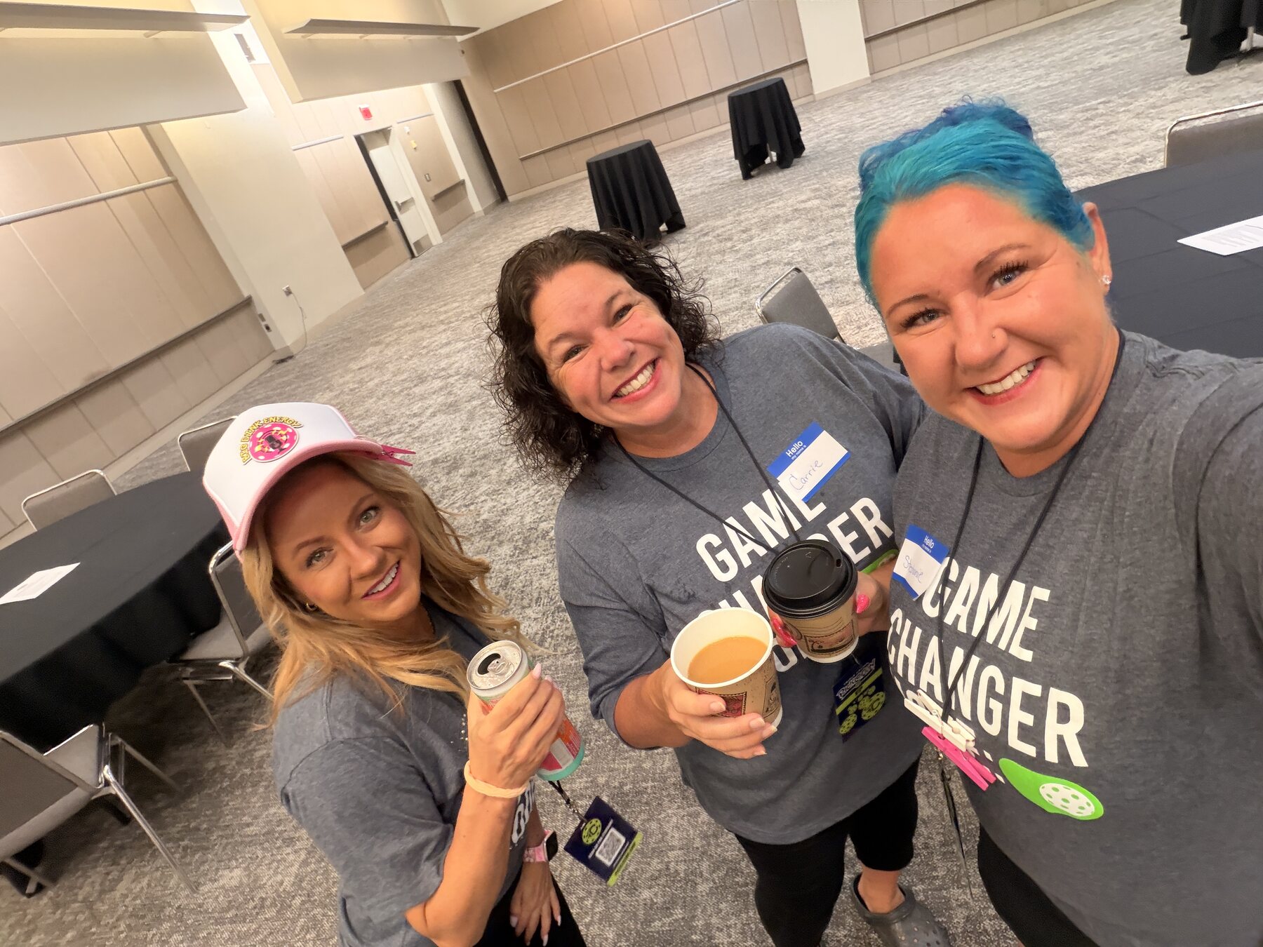 Three smiling event attendees in matching Game Changer shirts