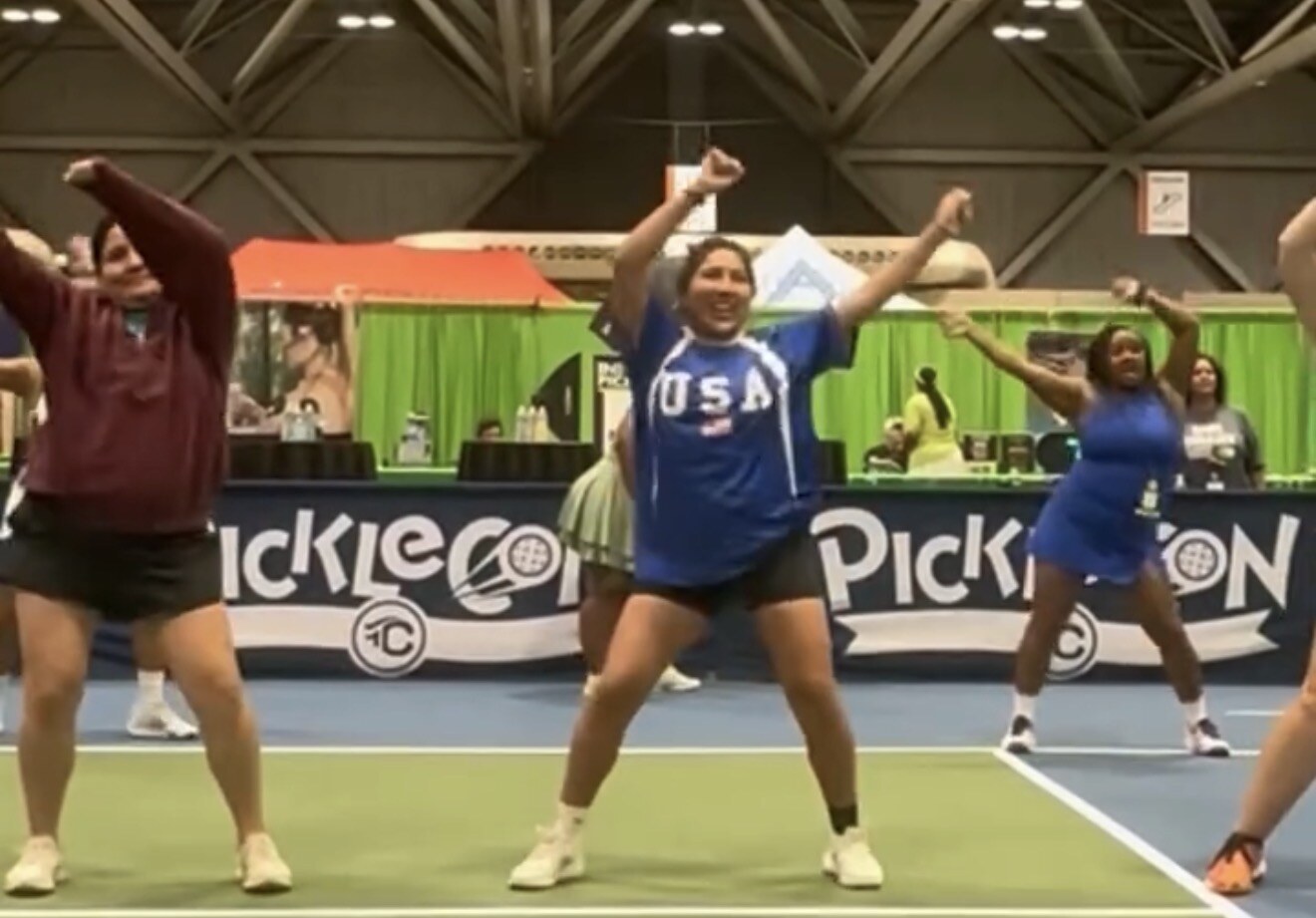 PickleCon attendees dancing together on a pickleball court