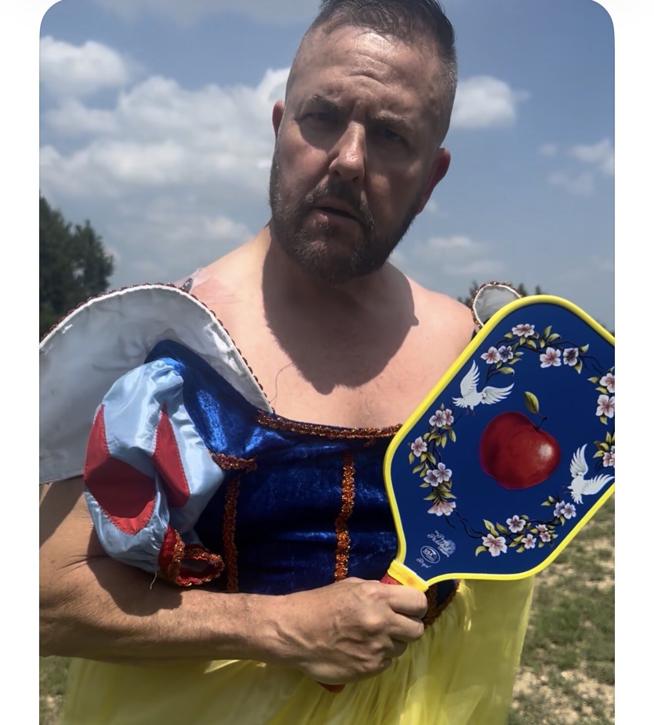 Guy Beveridge wearing a playful costume and holding a decorated pickleball paddle