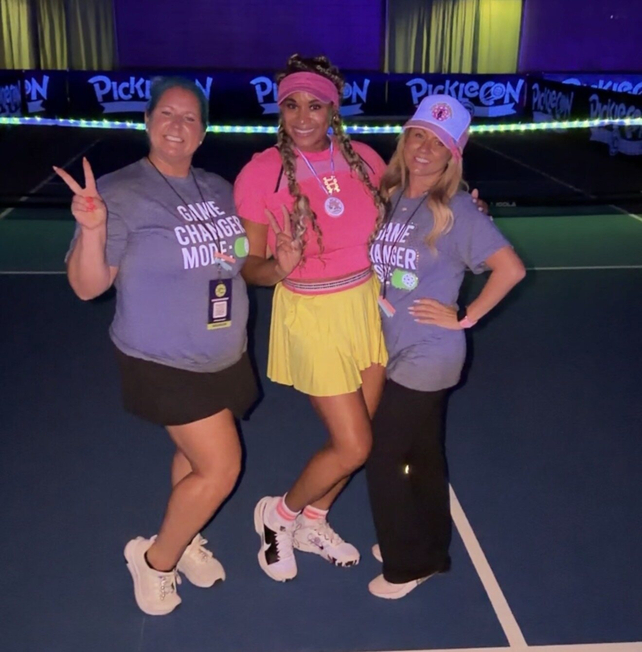 Three women posing together at a Glow Night pickleball event